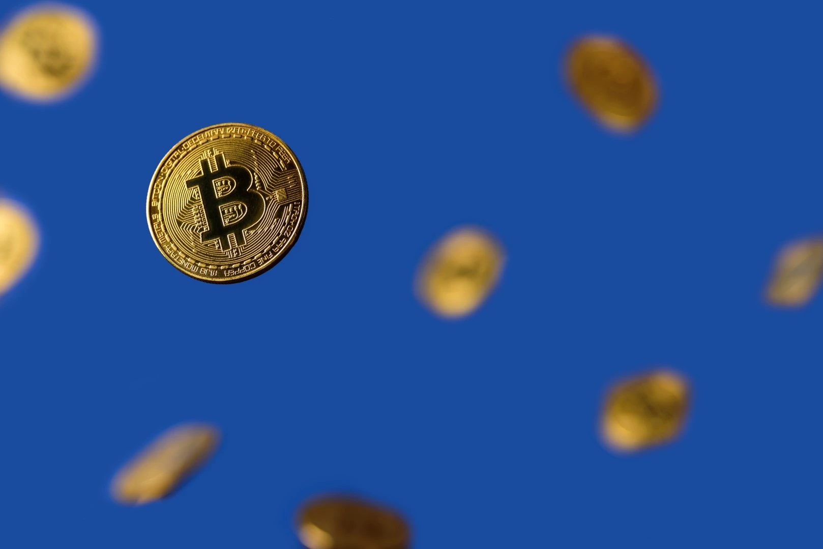 Como funciona la minería de Bitcoin; Monedas digitales con fondo azul.